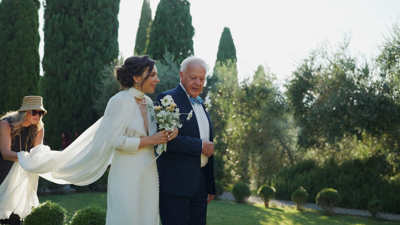 Bride in a flowing white veil walking through the garden of Castello di Vicarello towards the ceremony