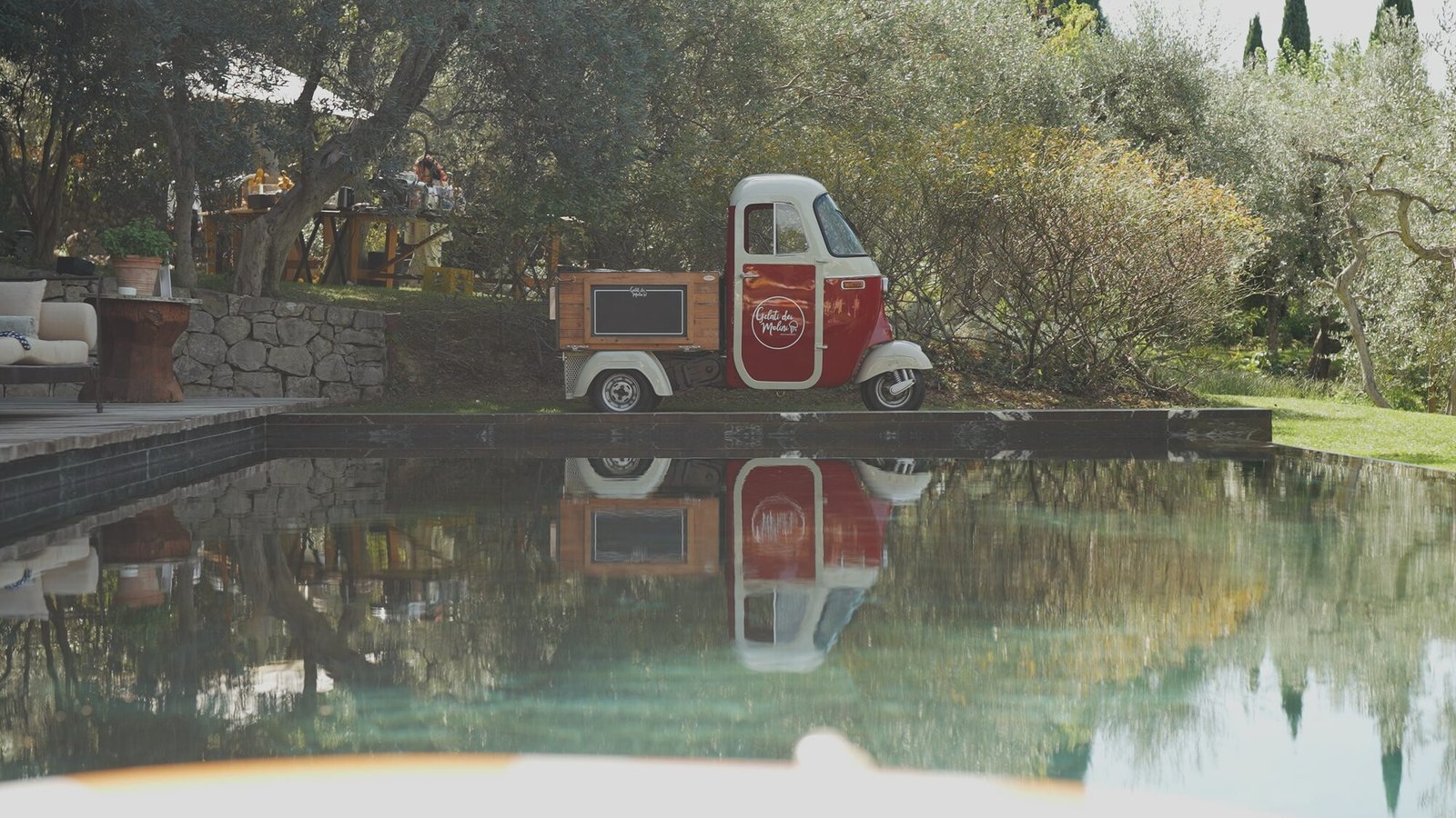 Vintage Ape Piaggio gelato truck reflected in the pool at Castello di Vicarello during the Sunday wedding brunch