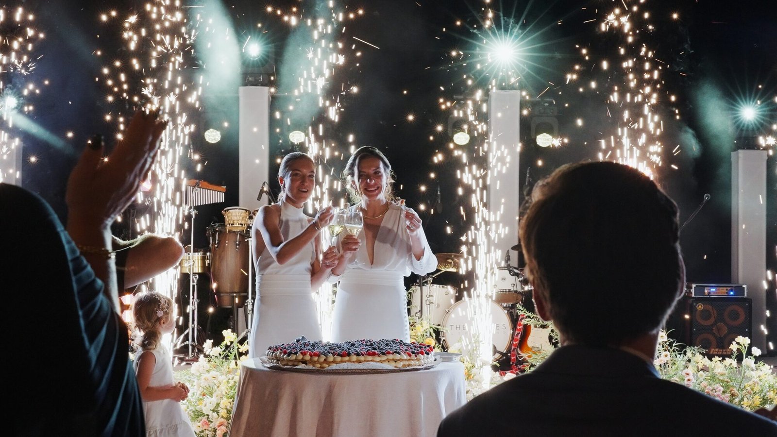 Two brides celebrating surrounded by sparklers during the evening reception at Castello di Vicarello